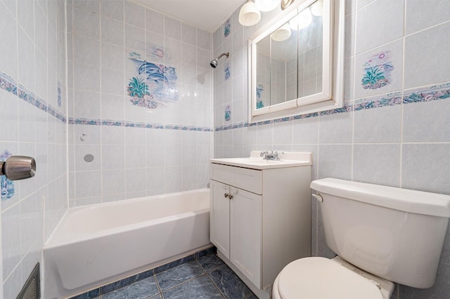 full bathroom with toilet, vanity, tile walls, and tiled shower / bath