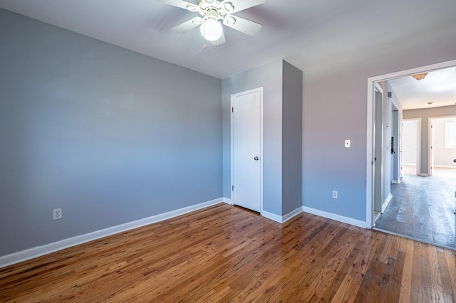 unfurnished bedroom with ceiling fan and dark hardwood / wood-style floors