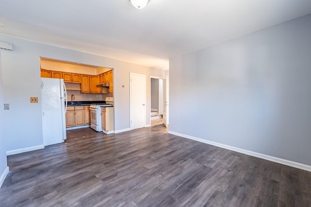 kitchen featuring white appliances, dark hardwood / wood-style flooring, and sink