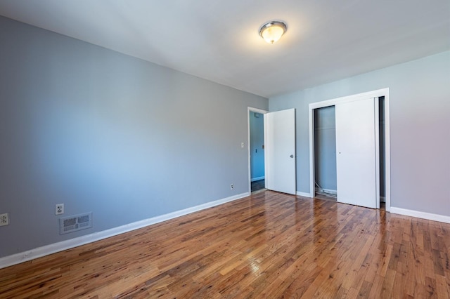 unfurnished bedroom featuring hardwood / wood-style flooring and a closet