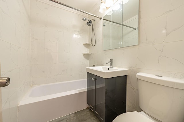 full bathroom featuring tiled shower / bath combo, toilet, vanity, tile walls, and ornamental molding