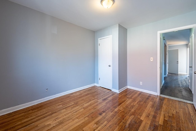 unfurnished bedroom featuring a closet and dark hardwood / wood-style floors