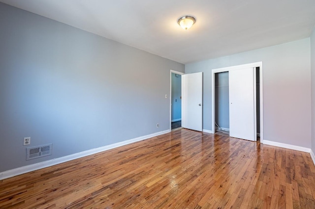 unfurnished bedroom with a closet and wood-type flooring