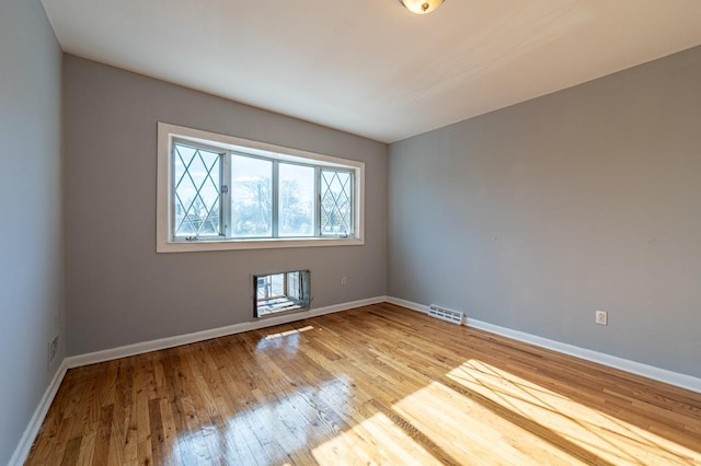 empty room featuring light wood-type flooring and heating unit