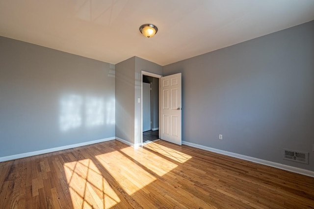 unfurnished room with wood-type flooring