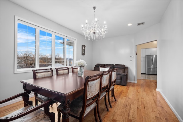 dining room featuring light hardwood / wood-style floors and a chandelier