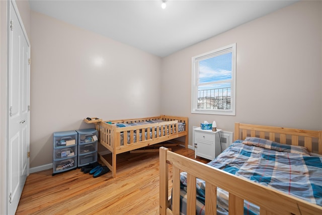 bedroom with light hardwood / wood-style floors and a closet