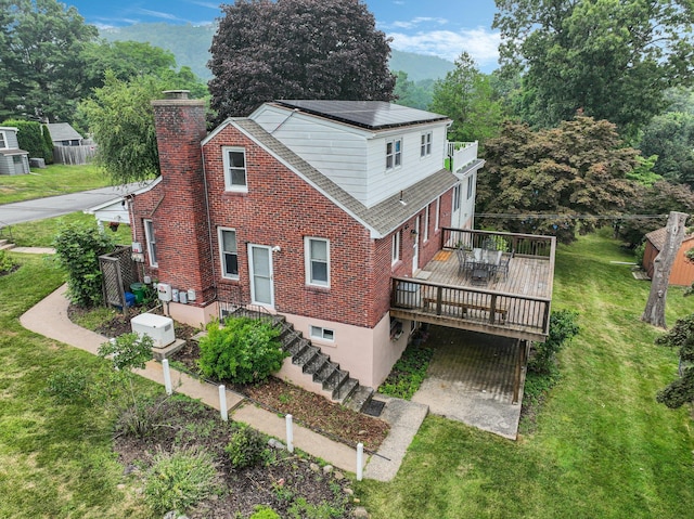 back of property featuring a yard and a wooden deck