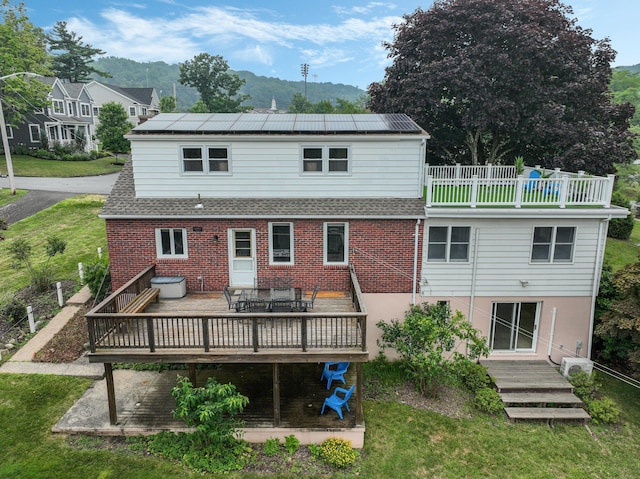 rear view of house with a yard and a wooden deck