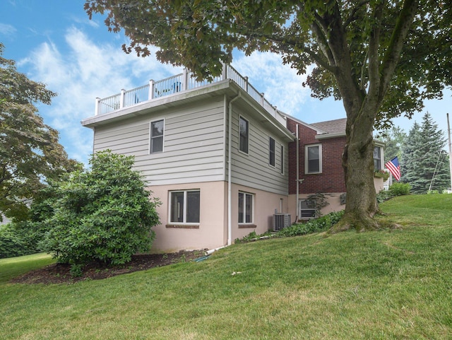 view of home's exterior with central air condition unit and a yard