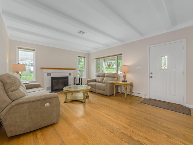 living room with a brick fireplace, a baseboard radiator, light wood-type flooring, and beam ceiling