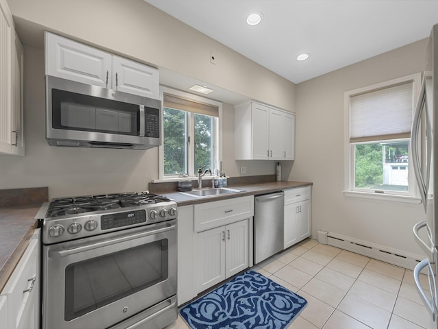 kitchen with plenty of natural light, appliances with stainless steel finishes, white cabinetry, and sink