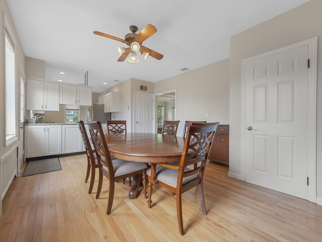 dining area with light hardwood / wood-style floors and ceiling fan