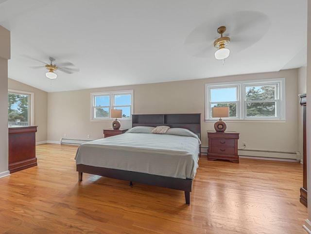 bedroom with multiple windows, a baseboard heating unit, ceiling fan, and light hardwood / wood-style floors