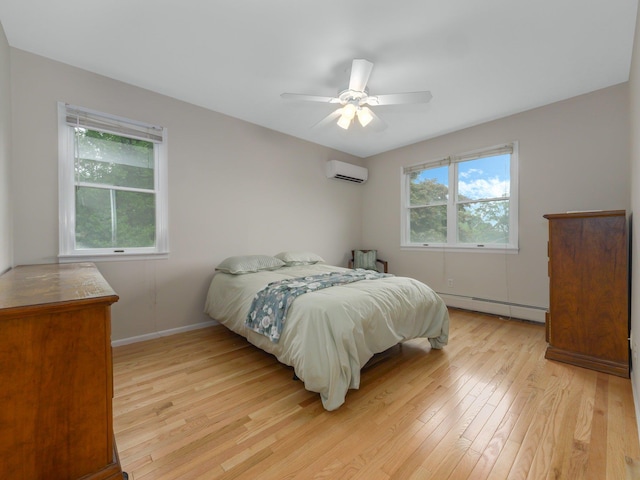 bedroom with an AC wall unit, ceiling fan, a baseboard radiator, and light hardwood / wood-style floors