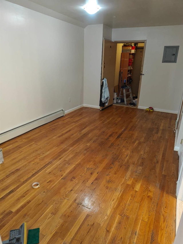 41-38 66th St Unit 2B, Woodside, NY 11377 - spare room featuring electric panel, hardwood / wood-style floors, a baseboard radiator, and baseboards