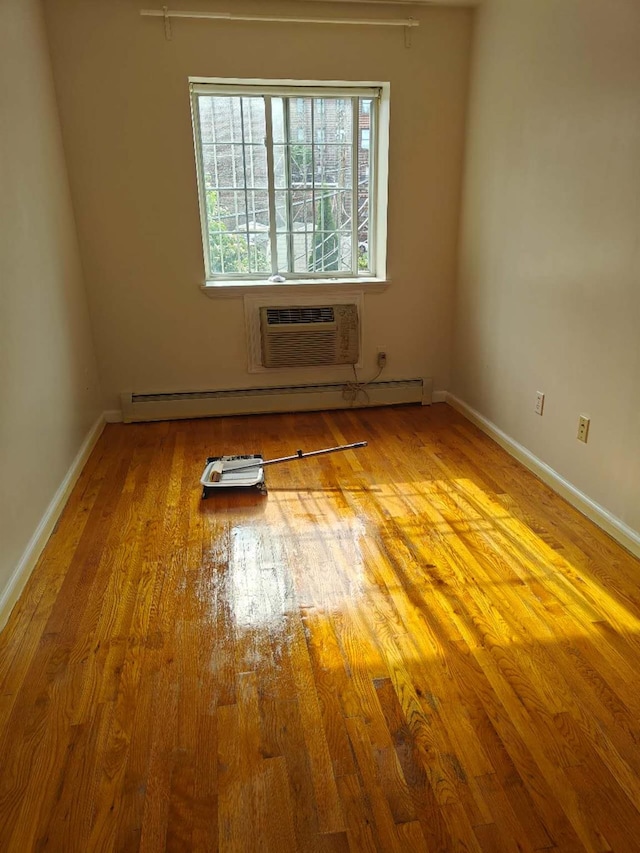 41-38 66th St Unit 2B, Woodside, NY 11377 - empty room with wood finished floors, baseboards, a wall mounted air conditioner, and a baseboard radiator