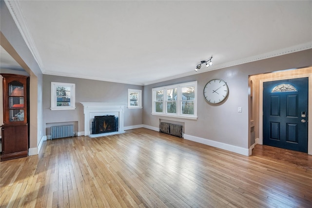 unfurnished living room featuring crown molding, radiator heating unit, and light hardwood / wood-style flooring