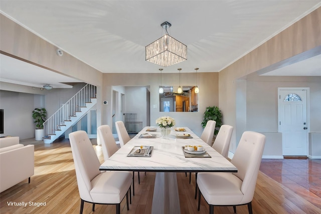 dining area featuring a notable chandelier, wood-type flooring, and ornamental molding