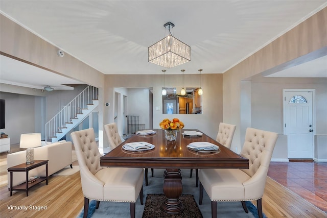 dining room featuring wood-type flooring, ornamental molding, and a chandelier