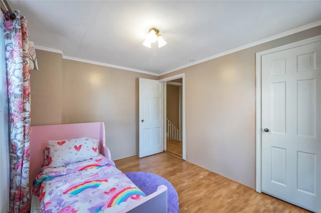 bedroom with ornamental molding and hardwood / wood-style floors