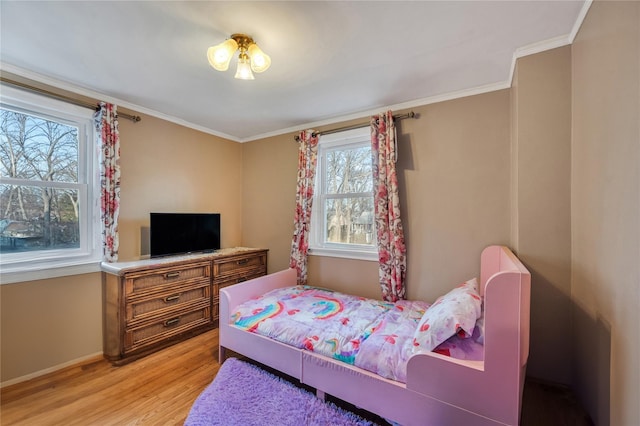 bedroom featuring ornamental molding and light hardwood / wood-style floors