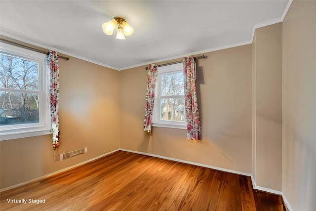 unfurnished room with hardwood / wood-style floors and ornamental molding