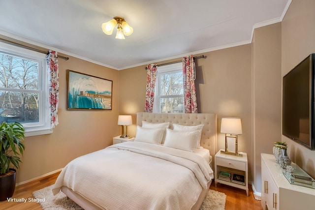 bedroom with crown molding and light hardwood / wood-style floors