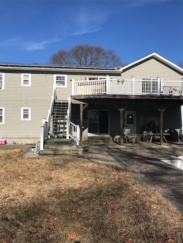 back of property featuring a deck and a patio area