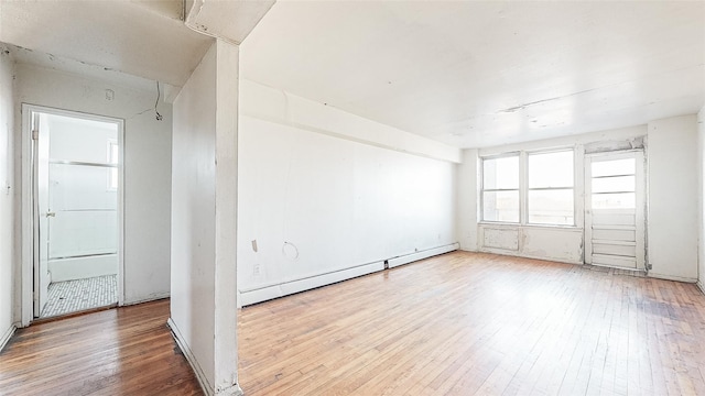 spare room with a baseboard radiator and light wood-type flooring