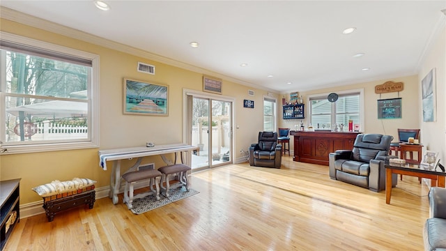 interior space with baseboards, crown molding, visible vents, and wood finished floors