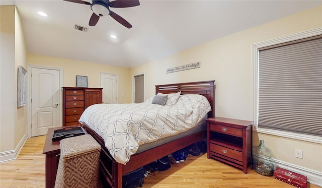 bedroom with baseboards, visible vents, wood finished floors, two closets, and recessed lighting