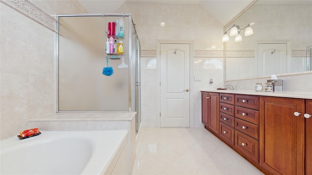 bathroom featuring a garden tub, tile walls, a stall shower, vaulted ceiling, and vanity