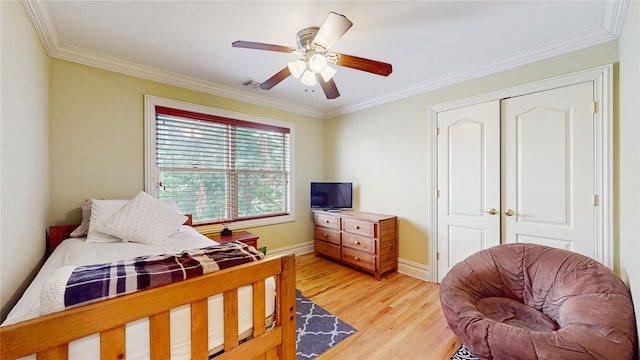 bedroom featuring light wood-style floors, ceiling fan, baseboards, and crown molding