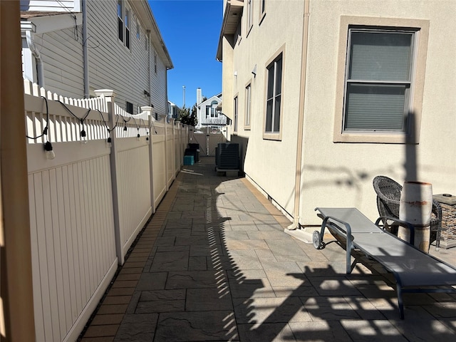 view of patio / terrace featuring central AC unit and fence