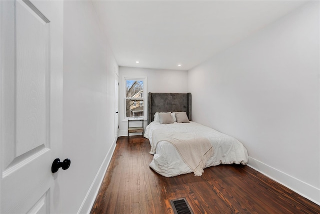 bedroom with dark hardwood / wood-style flooring