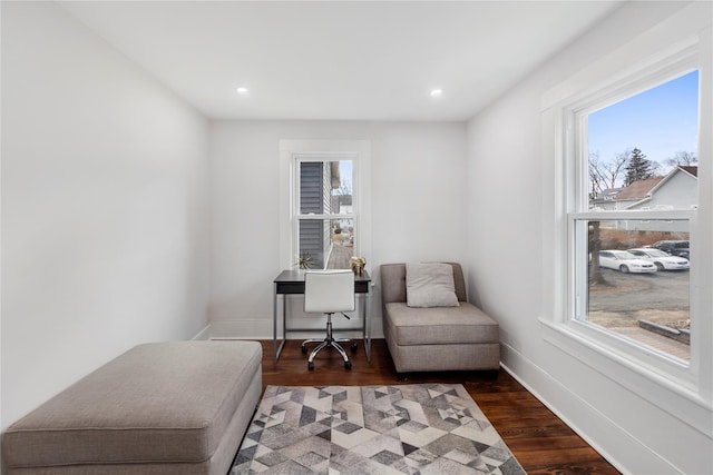 living area featuring a healthy amount of sunlight and dark hardwood / wood-style floors