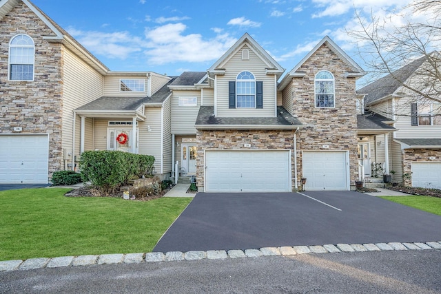 multi unit property featuring a front yard and a garage