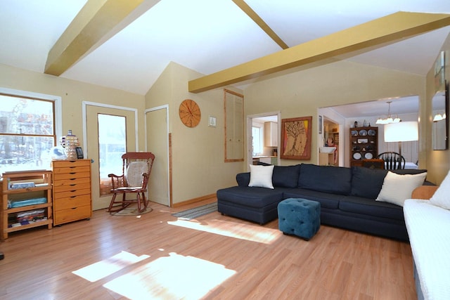 living room with an inviting chandelier, hardwood / wood-style flooring, and lofted ceiling with beams