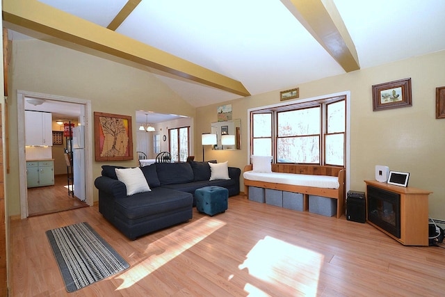 living room featuring vaulted ceiling with beams, a notable chandelier, plenty of natural light, and light wood-type flooring