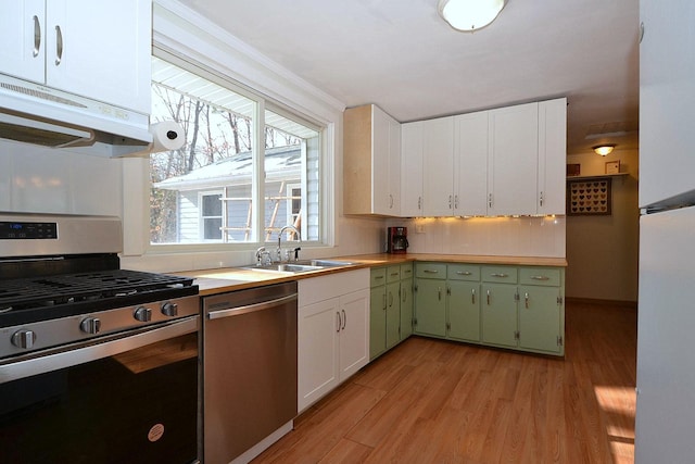 kitchen featuring sink, green cabinetry, stainless steel appliances, light hardwood / wood-style floors, and white cabinets