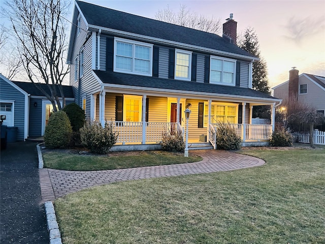 view of front of property featuring a porch and a lawn