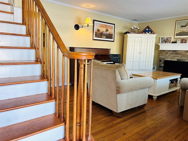 living room with ornamental molding, a brick fireplace, and dark wood-type flooring