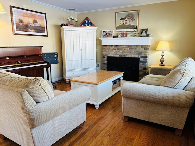 living room with crown molding, a fireplace, and dark wood-type flooring