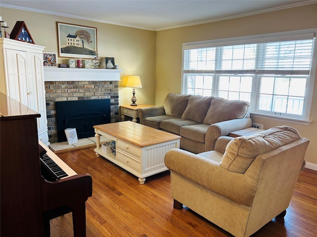 living room featuring crown molding, wood-type flooring, a brick fireplace, and plenty of natural light