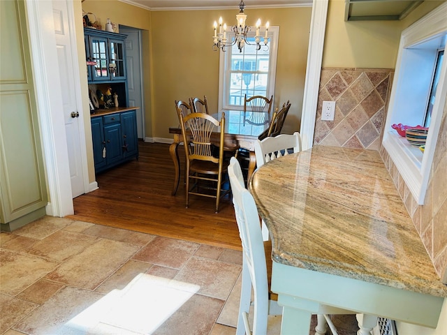 dining room with an inviting chandelier, crown molding, and light wood-type flooring