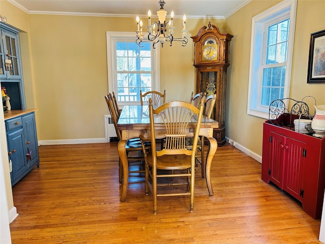 dining room featuring a notable chandelier, crown molding, and light hardwood / wood-style flooring