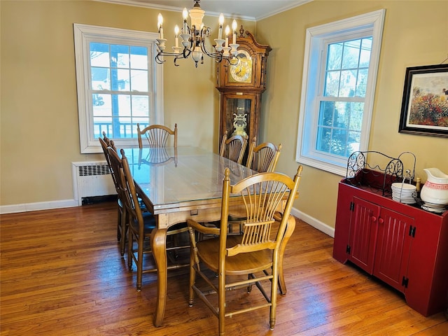 dining room with crown molding, radiator, a chandelier, and light hardwood / wood-style floors