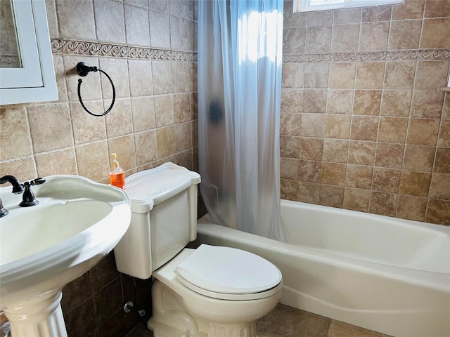 full bathroom featuring sink, shower / bath combo, tile walls, tile patterned flooring, and toilet