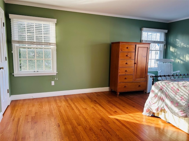 bedroom featuring ornamental molding and light hardwood / wood-style floors